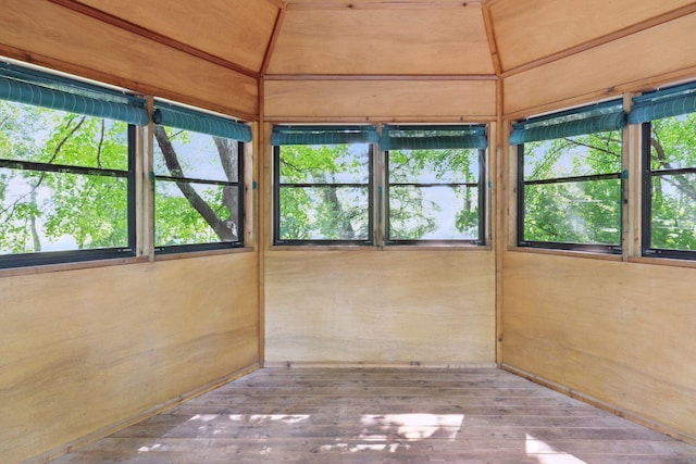 unfurnished sunroom with vaulted ceiling, a healthy amount of sunlight, and wood ceiling