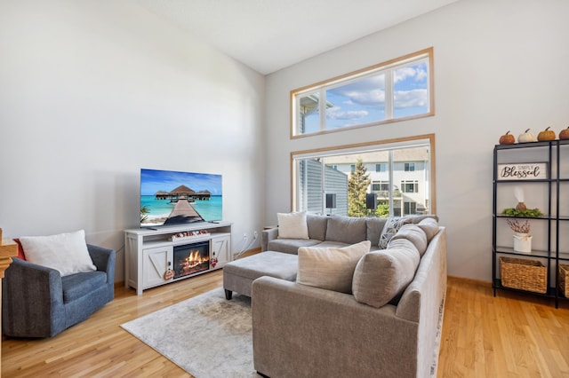 living room with light hardwood / wood-style flooring and a high ceiling