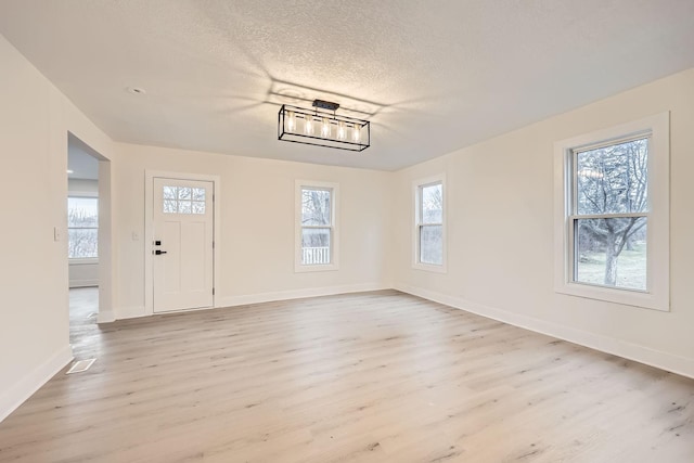 entryway with a textured ceiling and light wood-type flooring