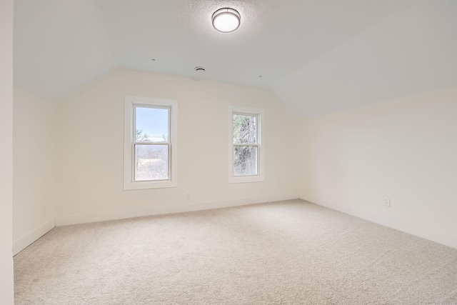 bonus room featuring carpet flooring, a textured ceiling, and lofted ceiling