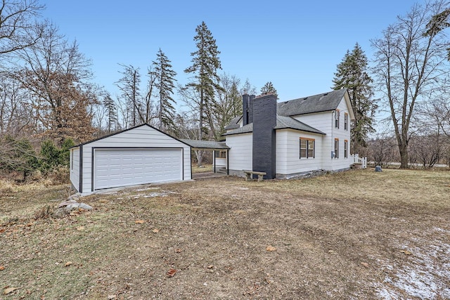 view of side of home featuring a carport, a garage, and an outdoor structure