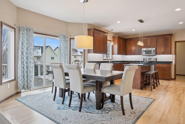 dining space with sink and light hardwood / wood-style flooring