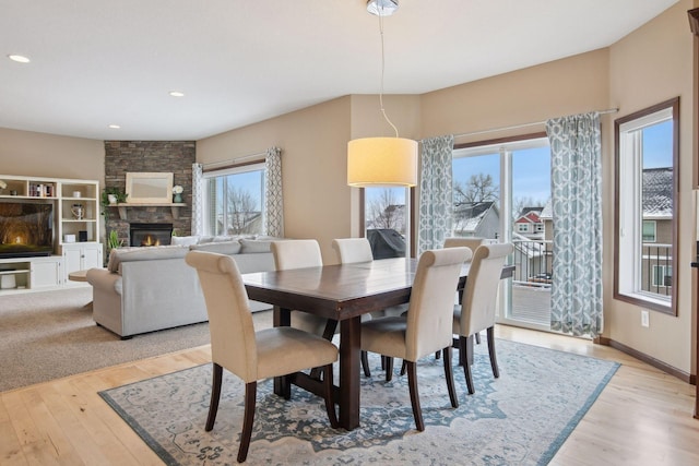 dining room with a fireplace and light hardwood / wood-style floors