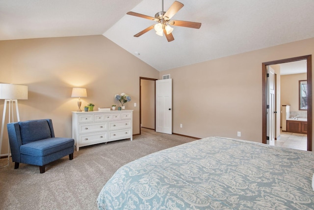 bedroom featuring ceiling fan, lofted ceiling, light carpet, and ensuite bath