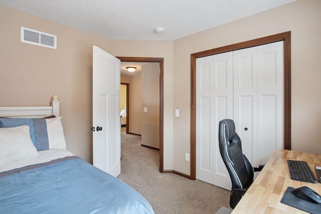 carpeted bedroom with a closet and a textured ceiling