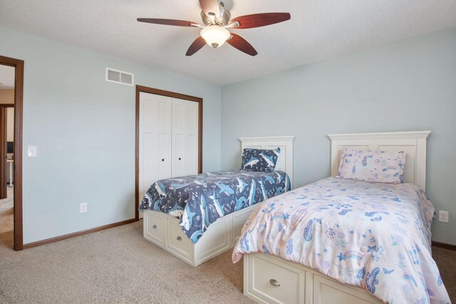 carpeted bedroom with a closet and ceiling fan