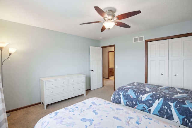 bedroom with light colored carpet, ceiling fan, and a closet