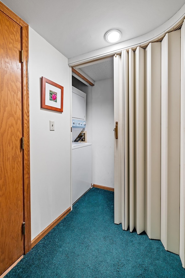 interior space featuring stacked washer and clothes dryer and dark carpet