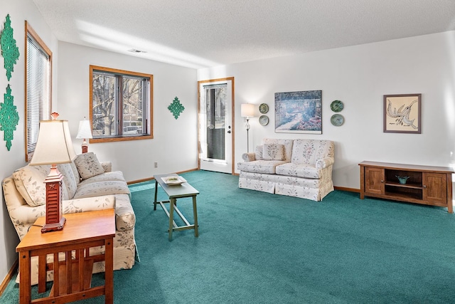 living area with a textured ceiling, carpet, visible vents, and baseboards