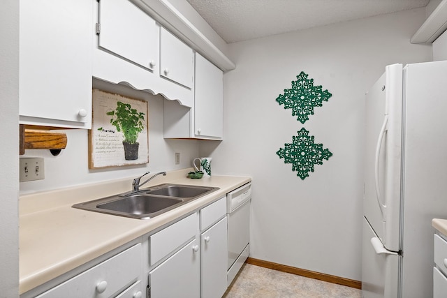 kitchen with white appliances, baseboards, light countertops, white cabinetry, and a sink