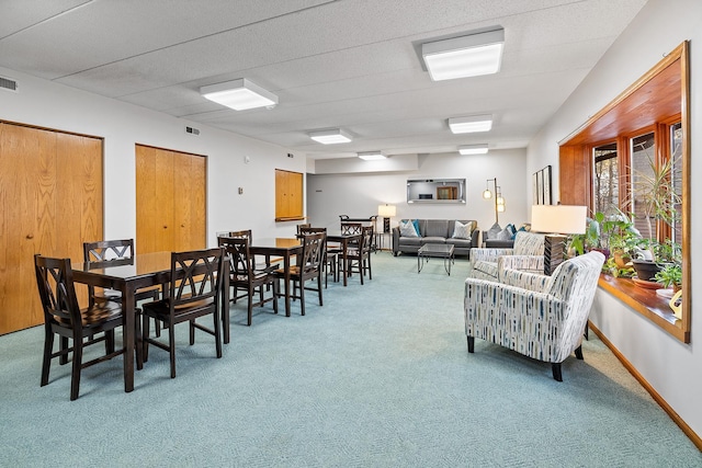 dining area with light colored carpet, visible vents, and baseboards