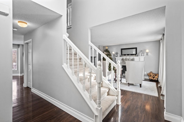 stairs featuring a textured ceiling and hardwood / wood-style floors