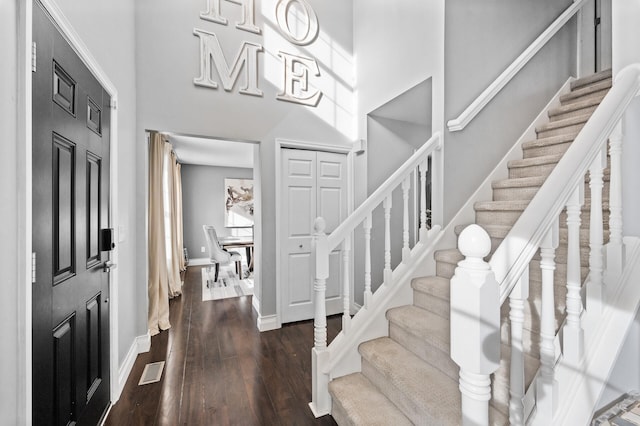 foyer with dark wood-type flooring and a high ceiling