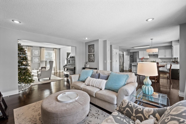 living room featuring dark hardwood / wood-style floors and a textured ceiling