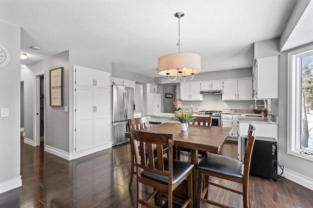 dining room featuring sink, a notable chandelier, and dark hardwood / wood-style flooring