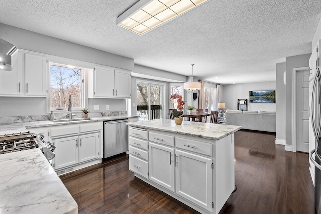 kitchen with dishwasher, a wealth of natural light, pendant lighting, white cabinets, and sink