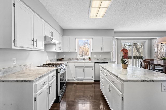 kitchen featuring a textured ceiling, stainless steel appliances, white cabinetry, and sink