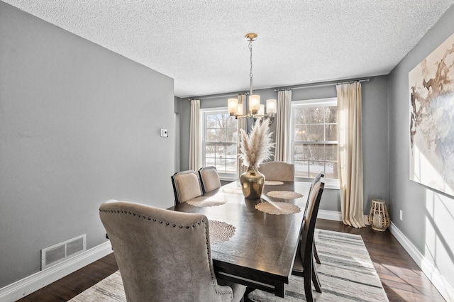 dining area featuring a textured ceiling, a chandelier, and dark hardwood / wood-style floors