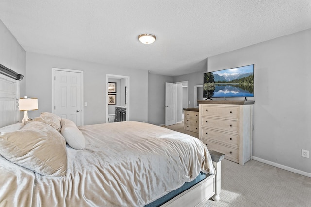 carpeted bedroom featuring connected bathroom and a textured ceiling