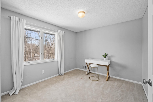 carpeted home office featuring a textured ceiling