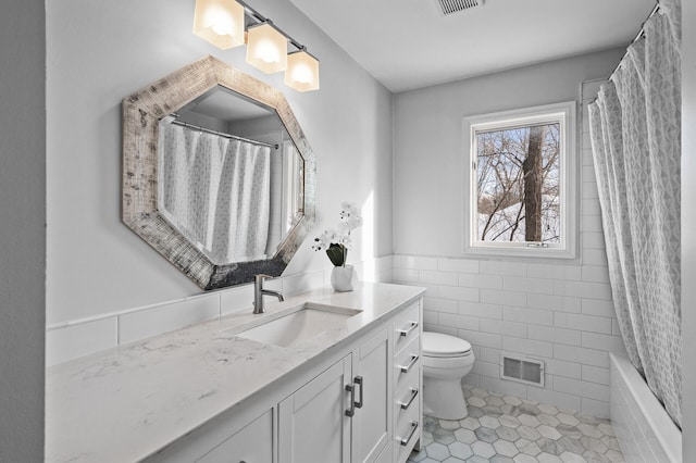 bathroom with tile patterned flooring, vanity, tile walls, and toilet