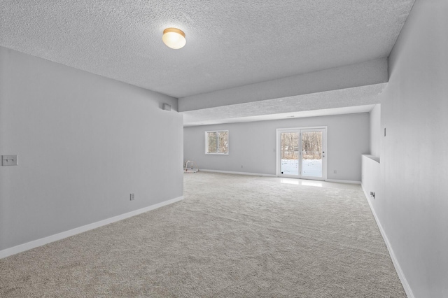 spare room featuring a textured ceiling and carpet flooring