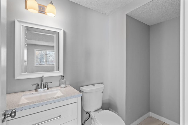 bathroom with a textured ceiling, toilet, and vanity