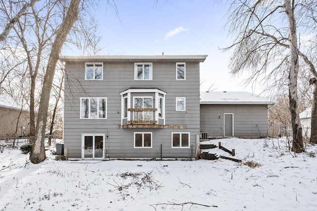 snow covered property featuring central AC