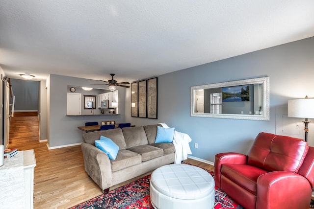 living room with ceiling fan and light wood-type flooring