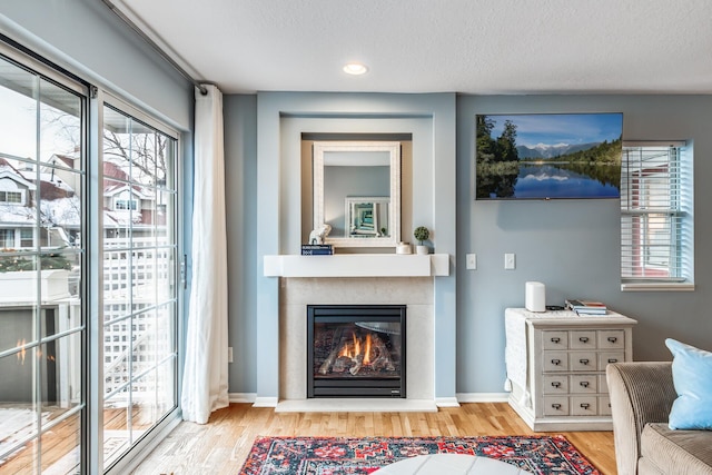 unfurnished living room featuring plenty of natural light, light wood-type flooring, and a textured ceiling