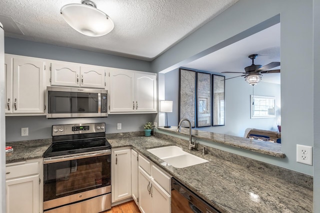 kitchen with white cabinetry, sink, ceiling fan, stainless steel appliances, and kitchen peninsula