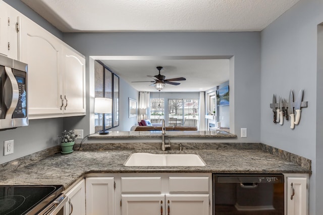 kitchen featuring appliances with stainless steel finishes, white cabinetry, ceiling fan, and sink