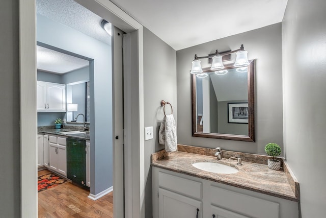 bathroom featuring vanity, wood-type flooring, and a textured ceiling