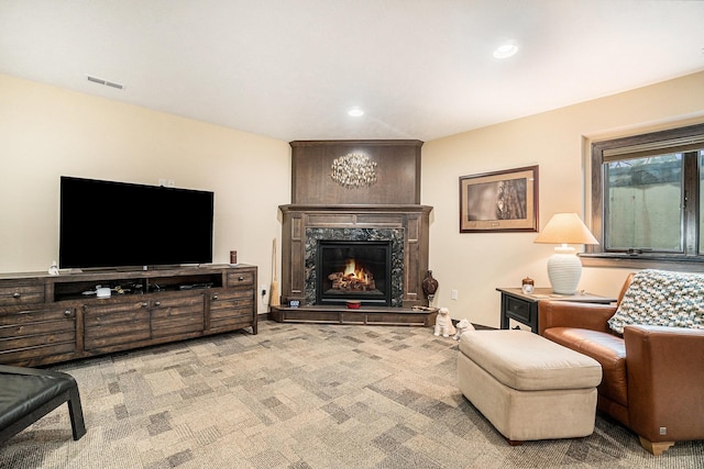 living room featuring a high end fireplace and light colored carpet