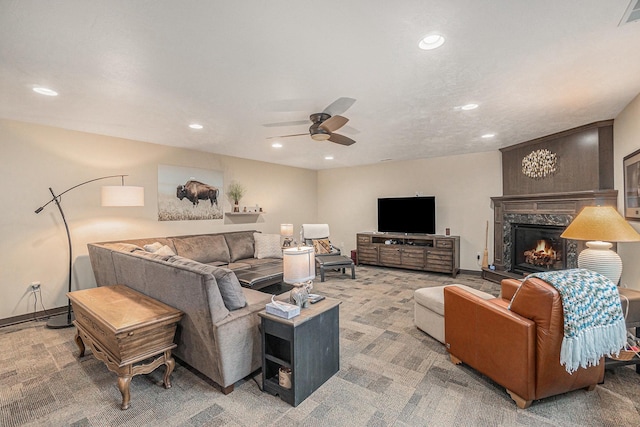 carpeted living room featuring ceiling fan and a high end fireplace