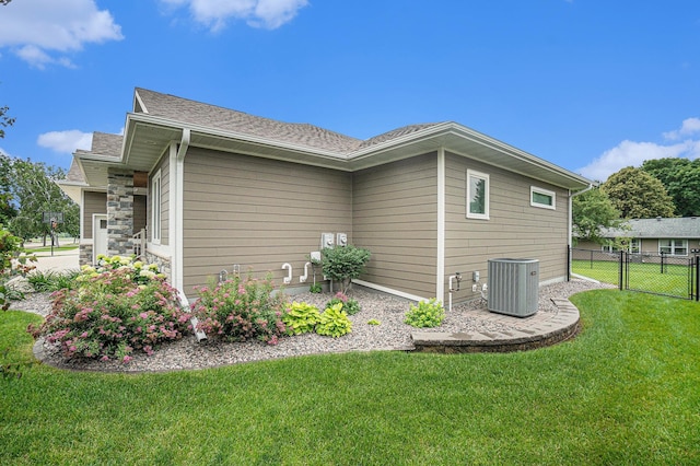 view of side of property with a yard and central AC unit