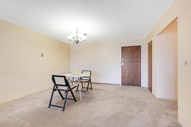 carpeted dining space with a textured ceiling and a notable chandelier