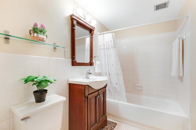 full bath with visible vents, toilet, shower / bath combo with shower curtain, vanity, and tile walls