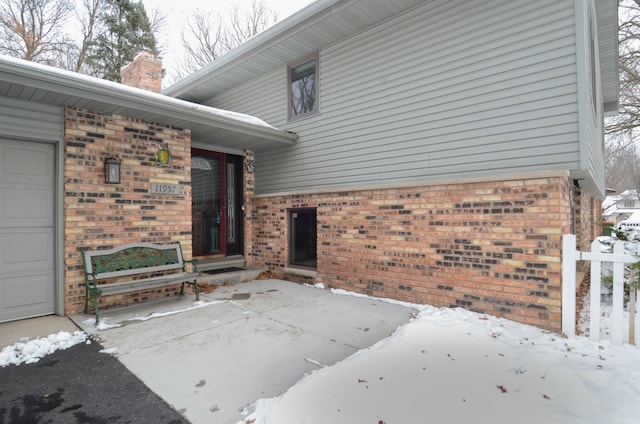 snow covered patio with a garage