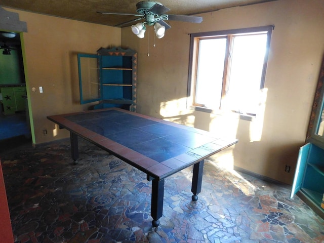 game room with ceiling fan and a textured ceiling