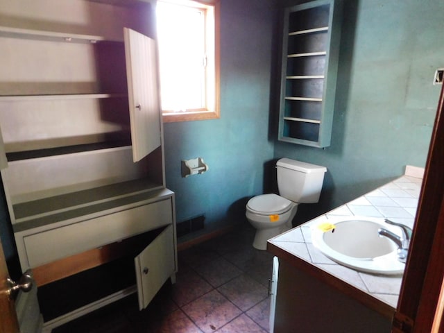 bathroom featuring tile patterned flooring, vanity, and toilet