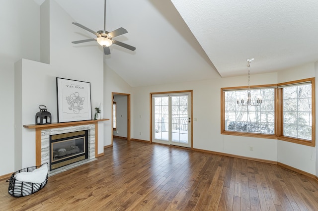 living room with a tile fireplace, wood-type flooring, ceiling fan with notable chandelier, and high vaulted ceiling