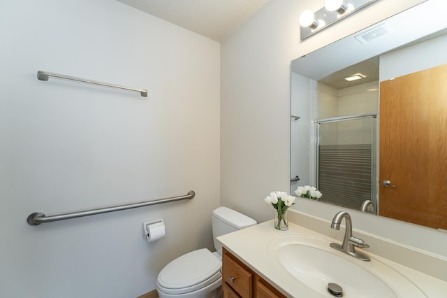 bathroom with walk in shower, vanity, and toilet