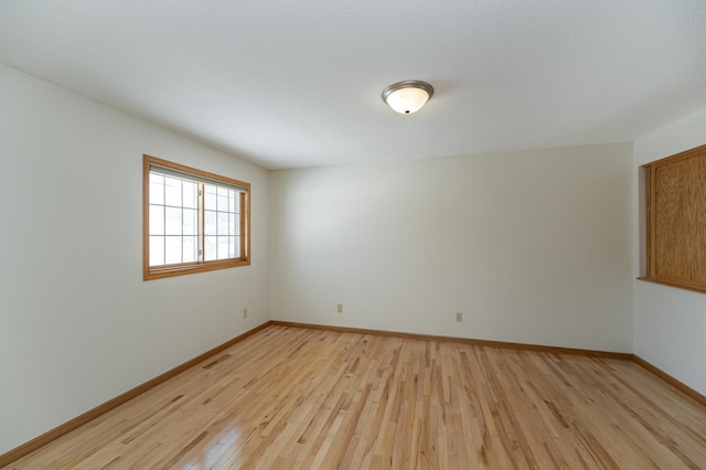 unfurnished room with light wood-type flooring