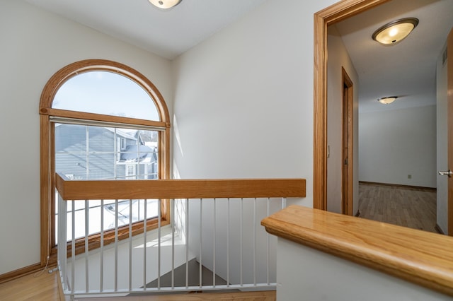 corridor with hardwood / wood-style flooring