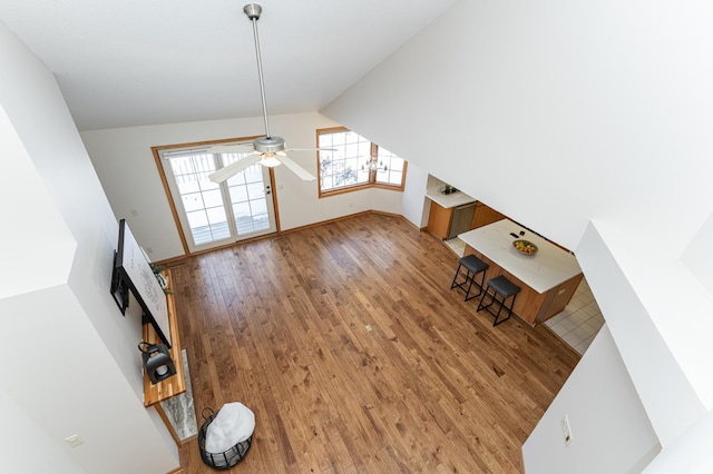 unfurnished living room featuring wood-type flooring, lofted ceiling, and ceiling fan