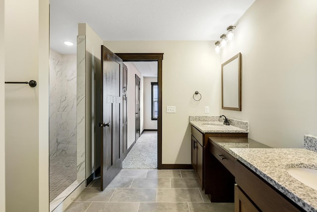 bathroom featuring tile patterned floors, vanity, and tiled shower