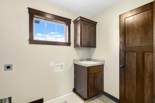 washroom with hookup for an electric dryer, washer hookup, cabinets, and sink