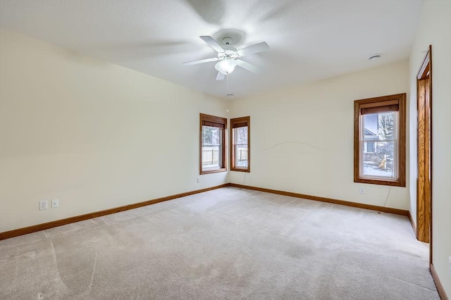 carpeted spare room featuring ceiling fan