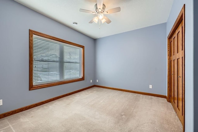 unfurnished bedroom with ceiling fan and light colored carpet